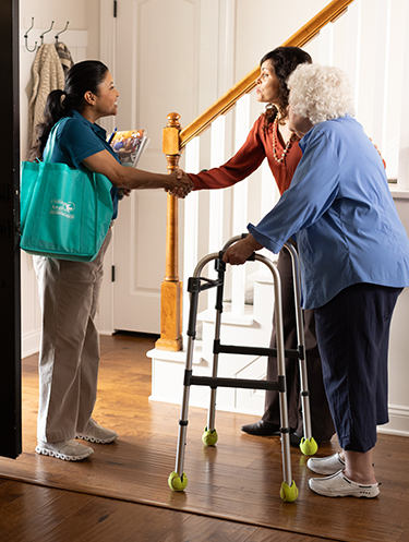 Adult child and senior mother meet a Visiting Angels for an in-home consultation.