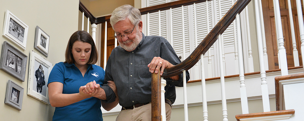 A Visiting Angels caregiver engaging with an elderly man outdoors, highlighting the warmth of in-home care services.